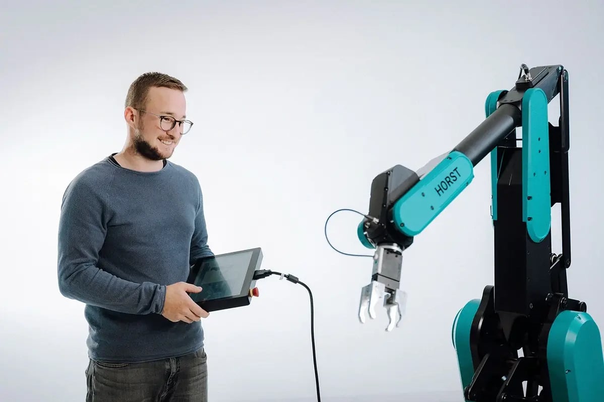 Ein Mann bedient einen HORST-Roboter von fruitcore robotics.